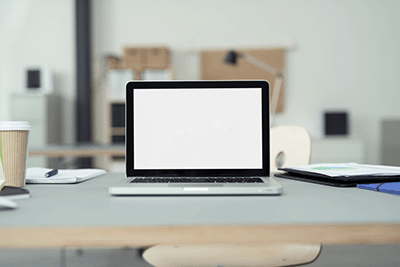 Close up Laptop Computer on Top of Office Table of a Businessman with Empty White Screen, Emphasizing Copy Space_